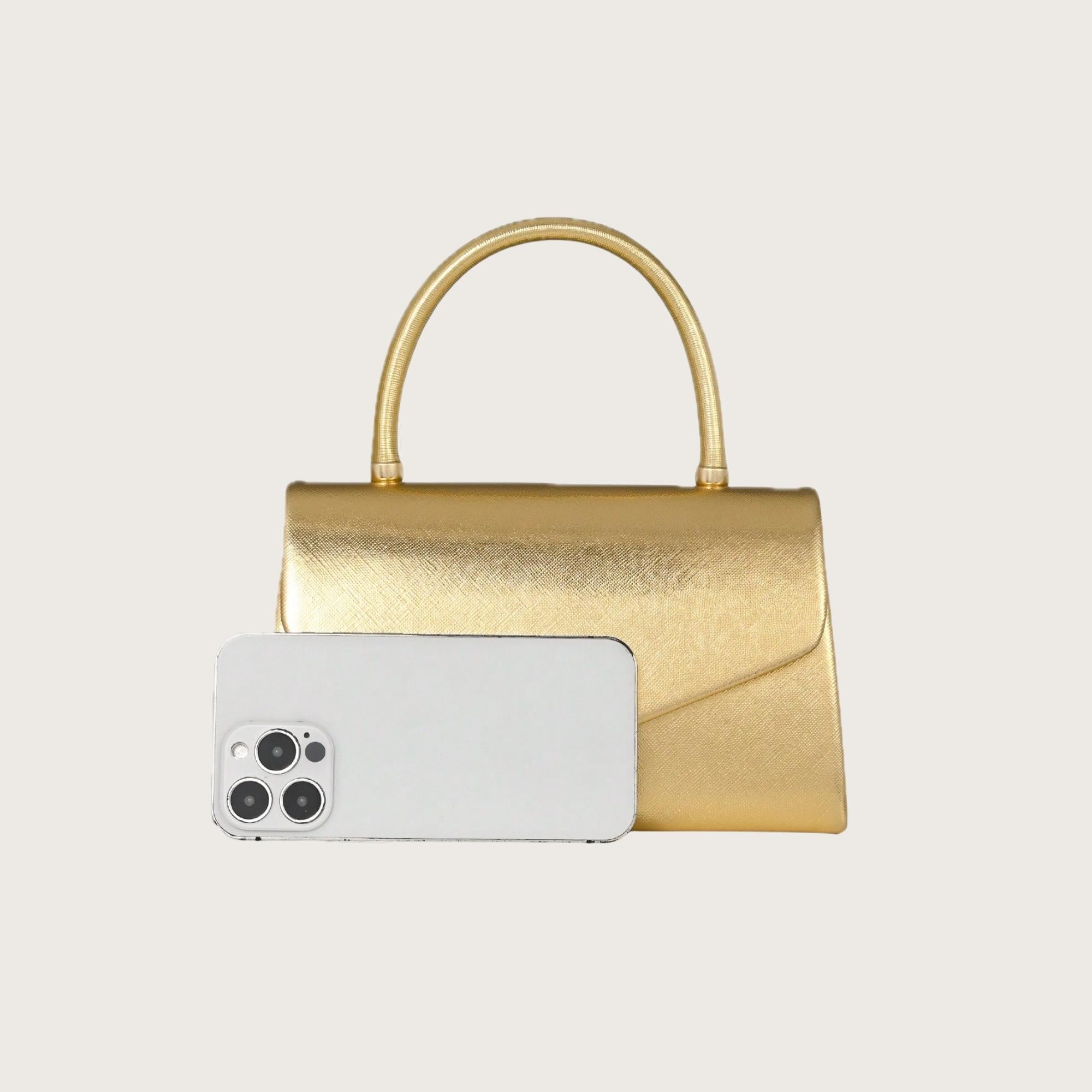 Gold handbag with a smartphone on a light gray background